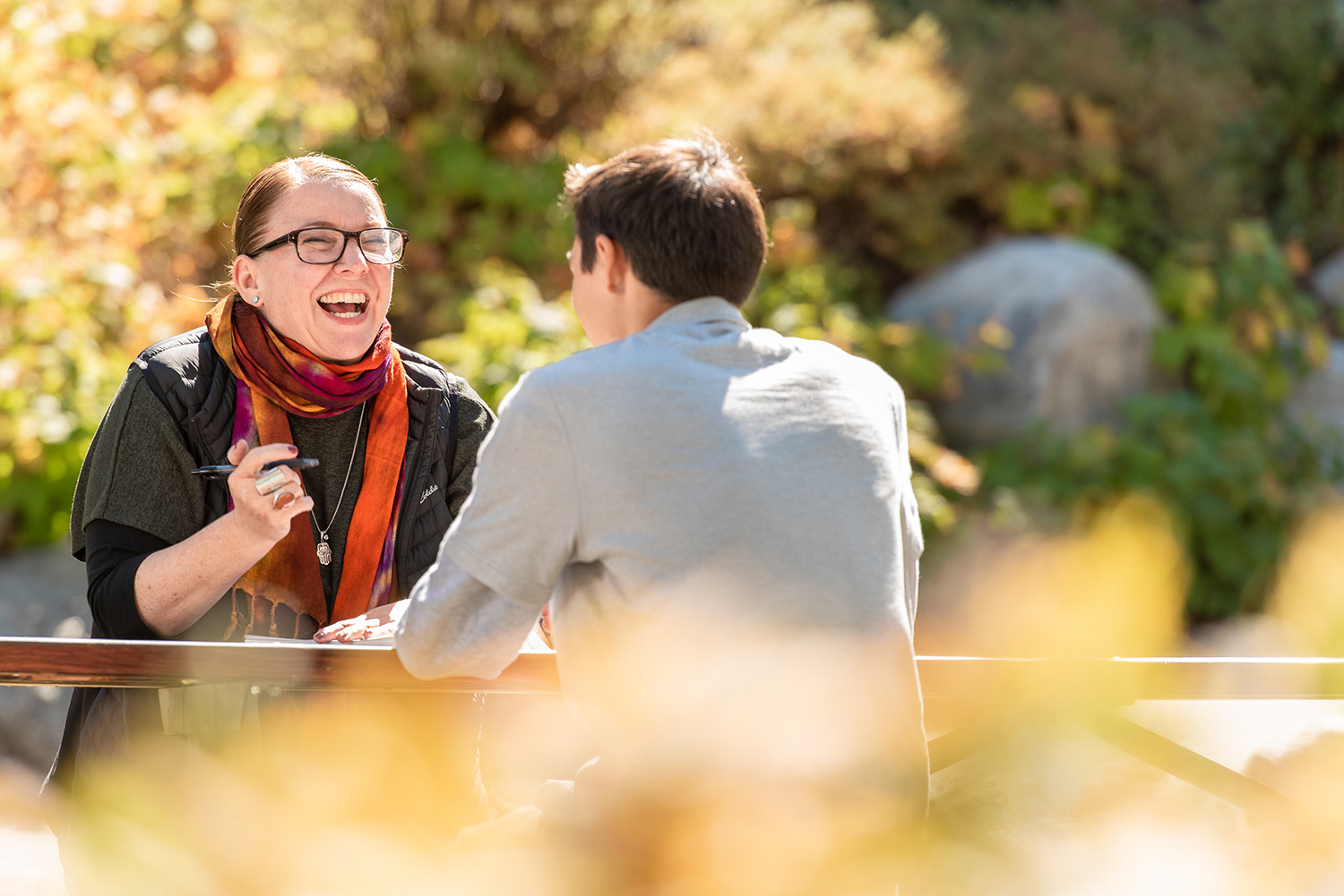 teacher with student at picnic table outside
