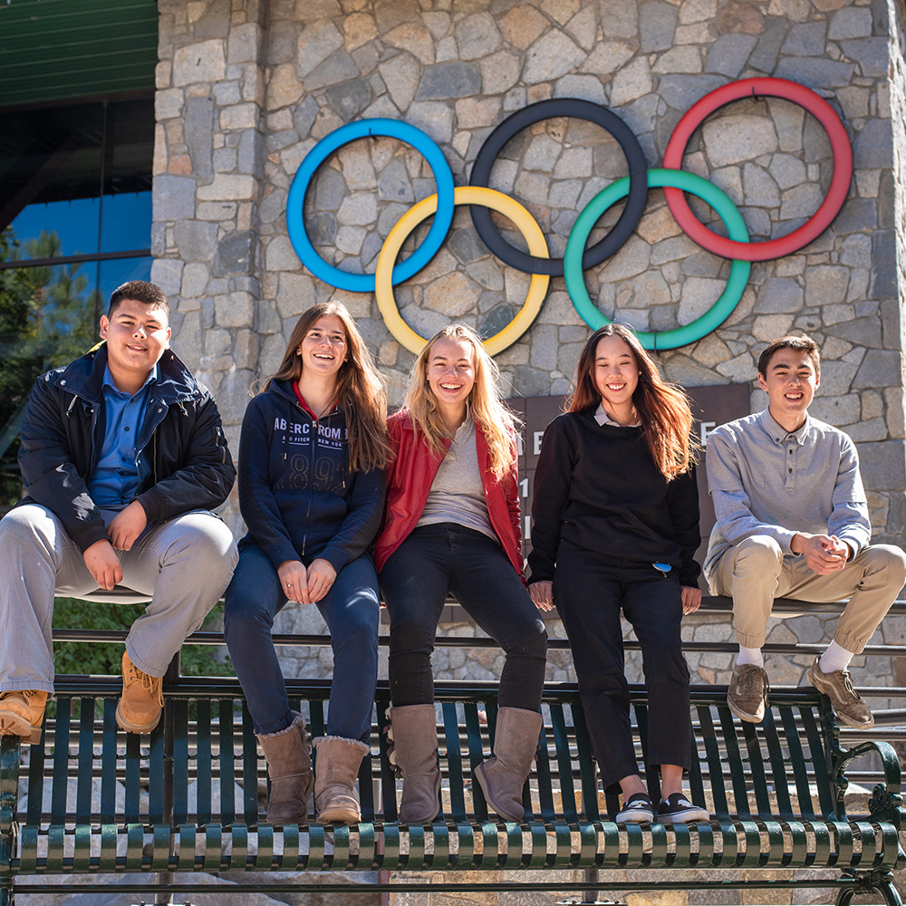 students sitting outside on railing