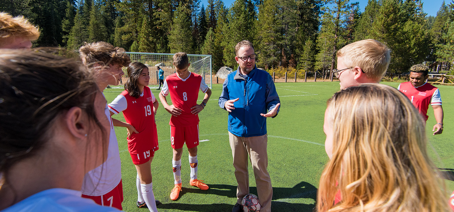 soccer coach in huddle with team