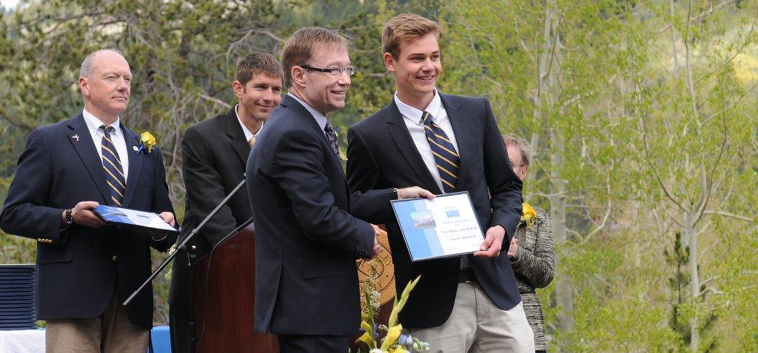 Head of School presenting student with a plaque