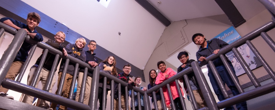 Students with Head of School leaning on railing