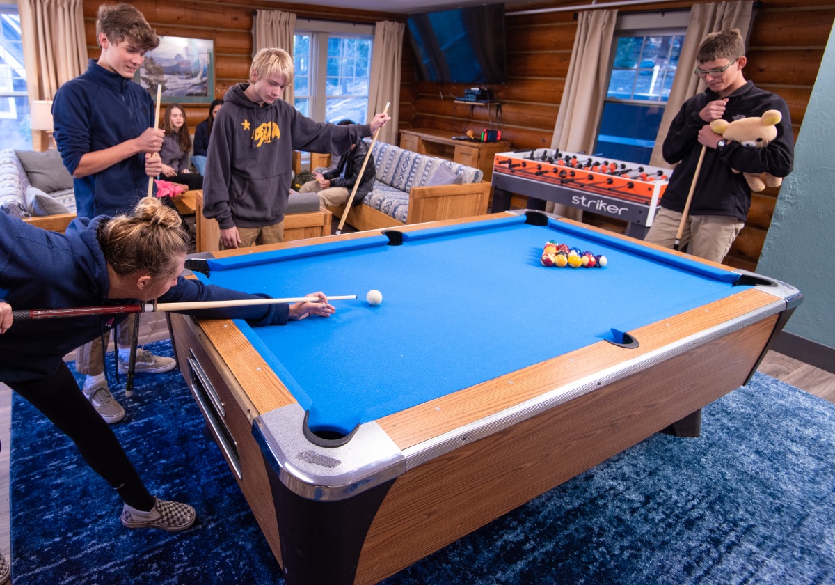 Students playing pool in lodge